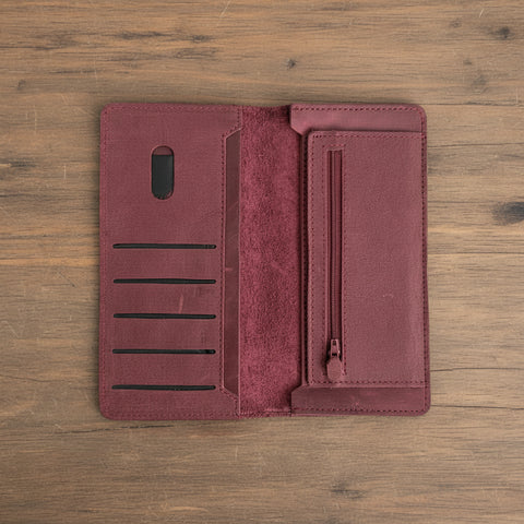 Maroon phone wallet case with card slots and a zipper on a white background