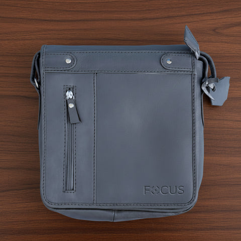 Gray leather crossbody bag with 'FOCUS' branding on a light blue background